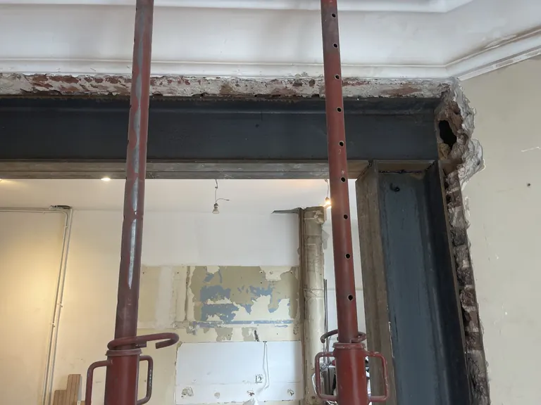 Poutre et montant métalliques avec étais pendant des travaux sur un mur