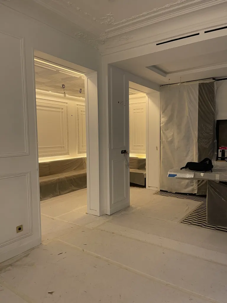 Enfilade de pièces en rénovation, moulures, boiseries et éclairage indirect