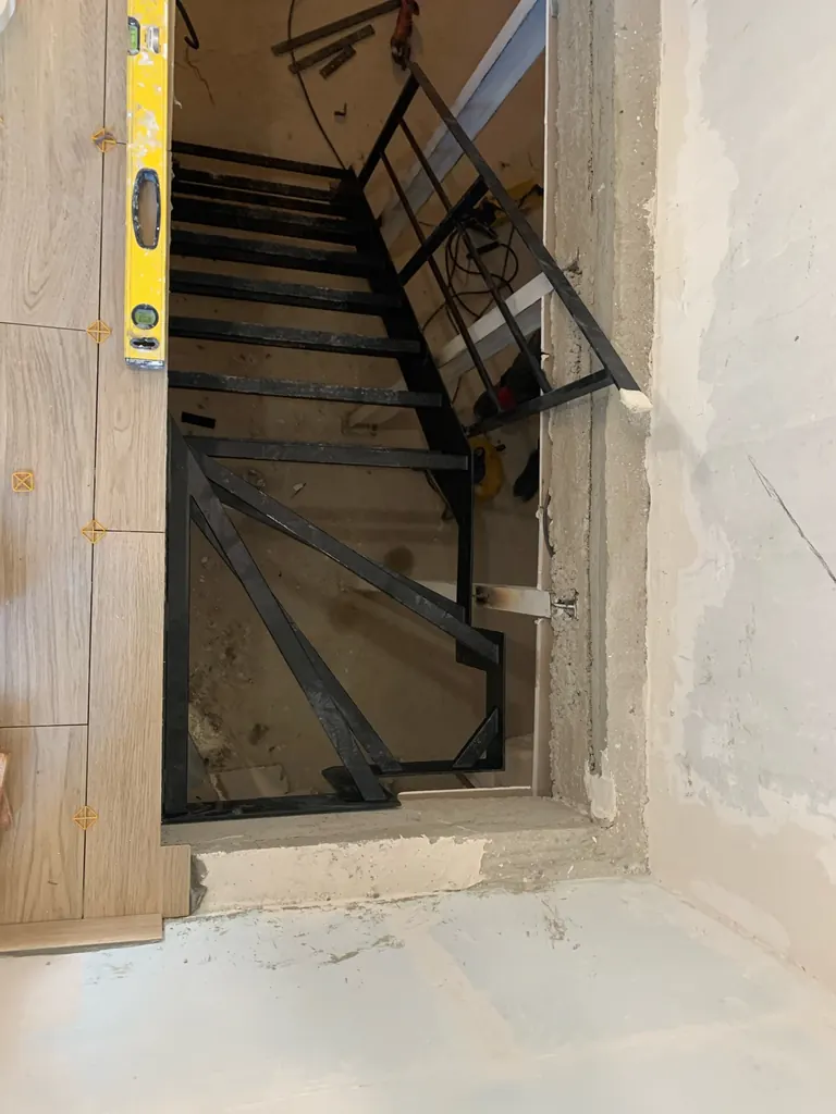 Structure d’escalier métallique en cours d’installation dans une trémie