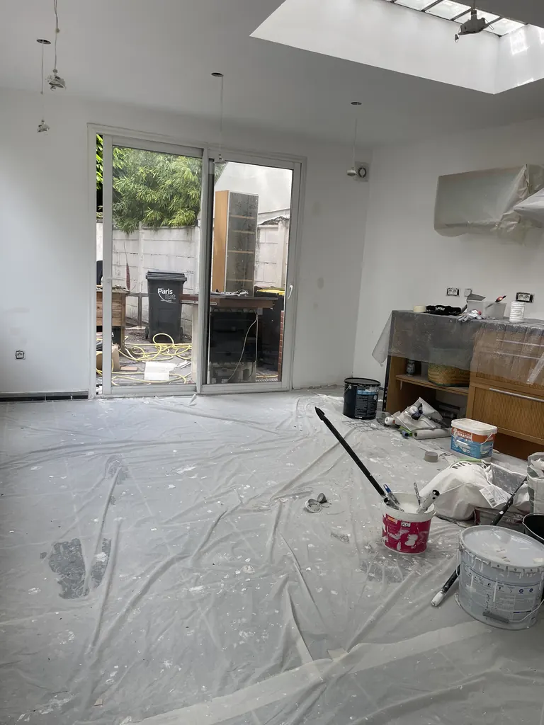 Pièce en cours de finition avec baie vitrée et ouverture vitrée en toiture