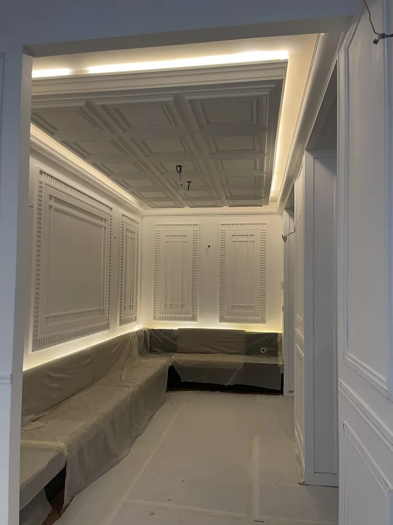Salon en rénovation avec plafond à caissons, moulures et éclairage indirect
